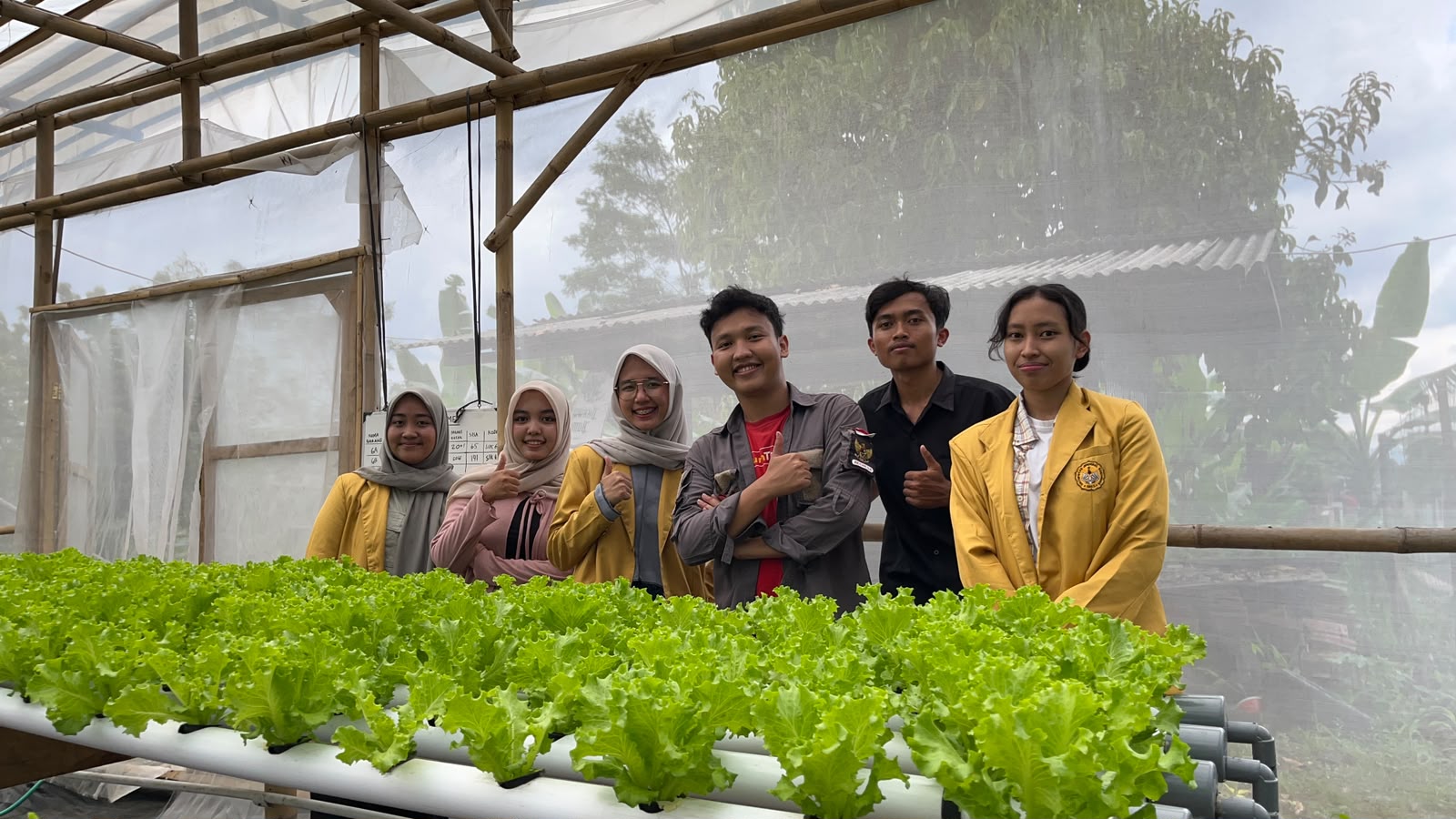 Mahasiswa magang berfoto di greenhouse Dhawuh Bumi