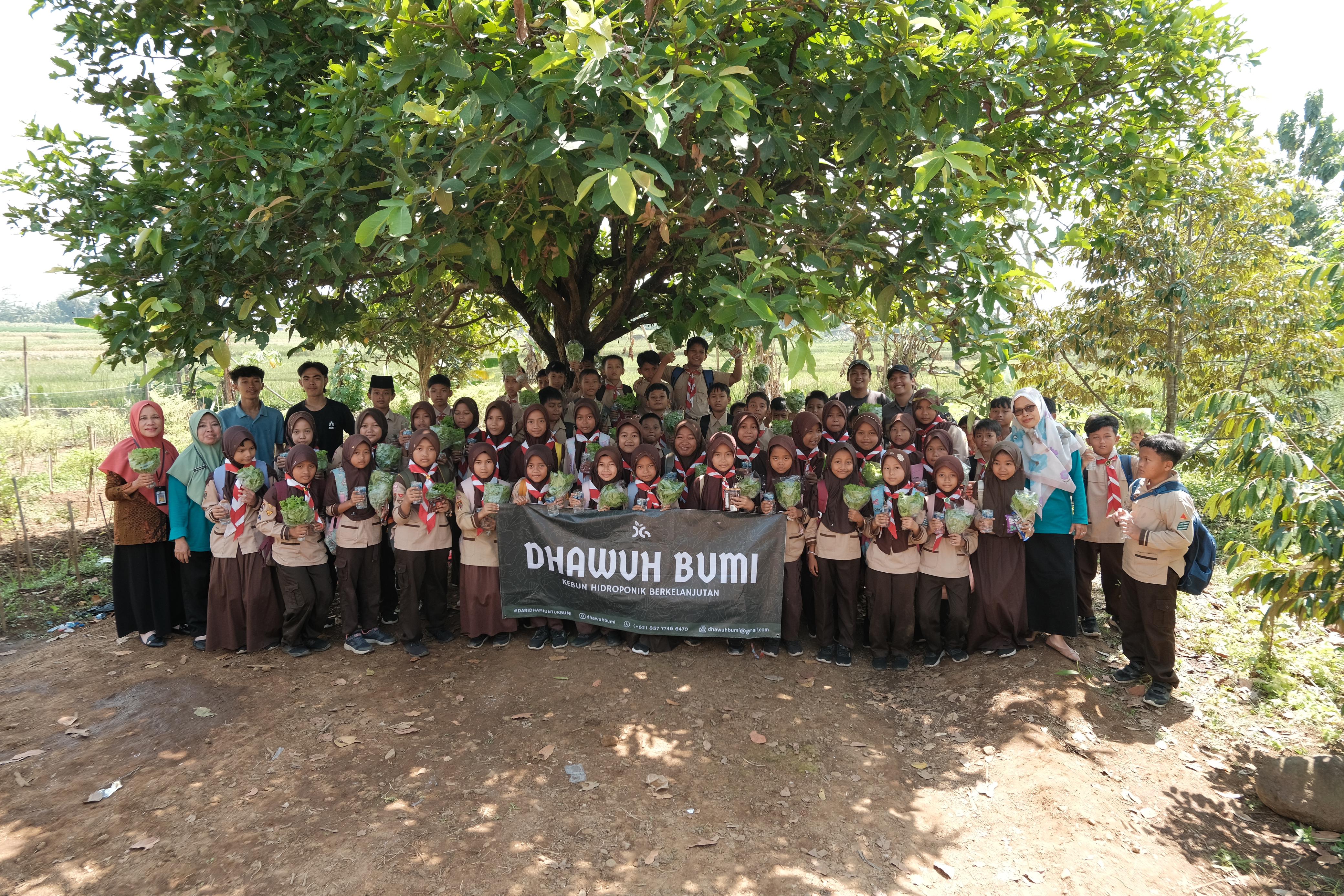 Satu angkatan siswa dan guru berfoto bersama membawa spanduk Dhawuh Bumi